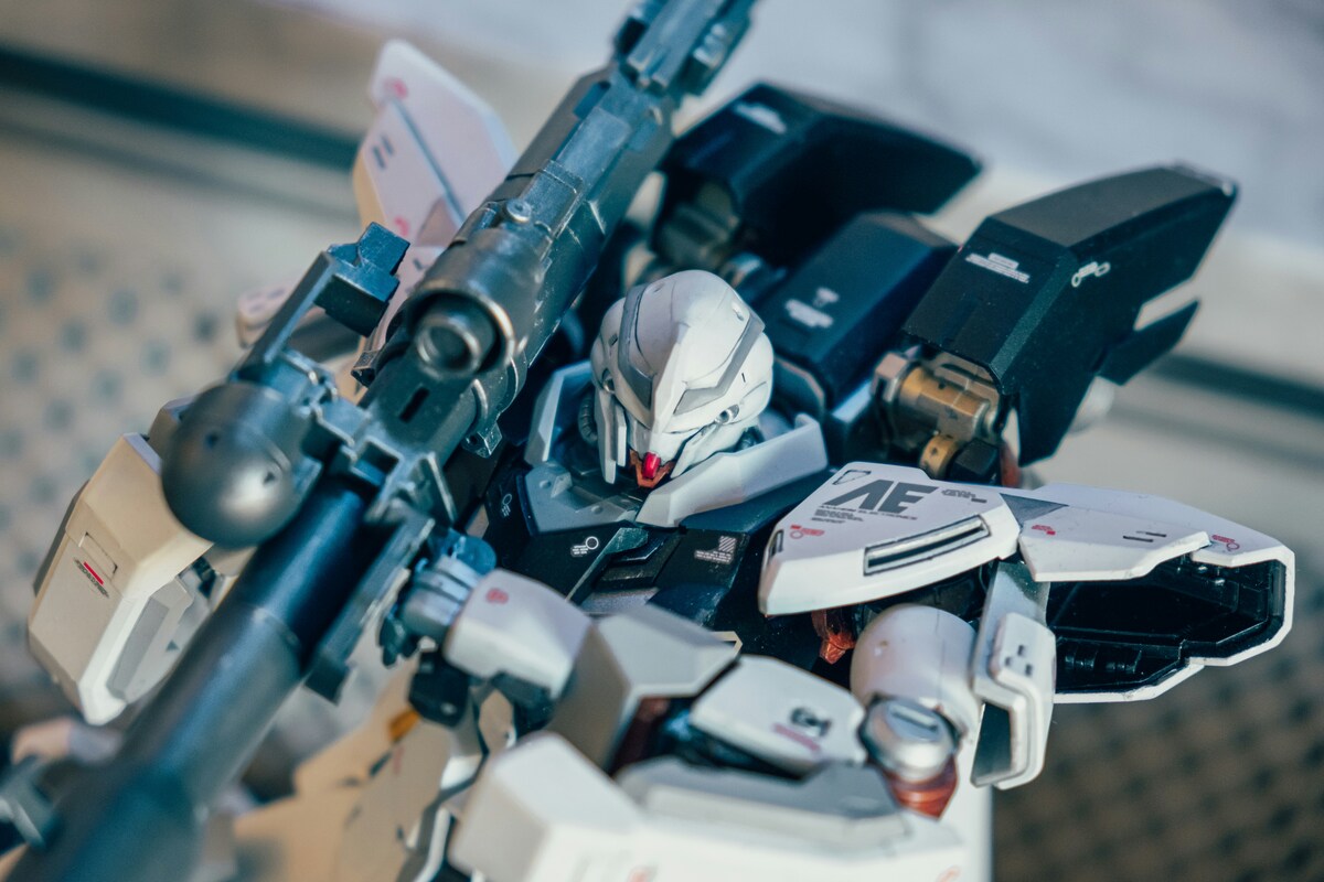 Close-up of a finished Gundam with decals and metallic-looking weapon