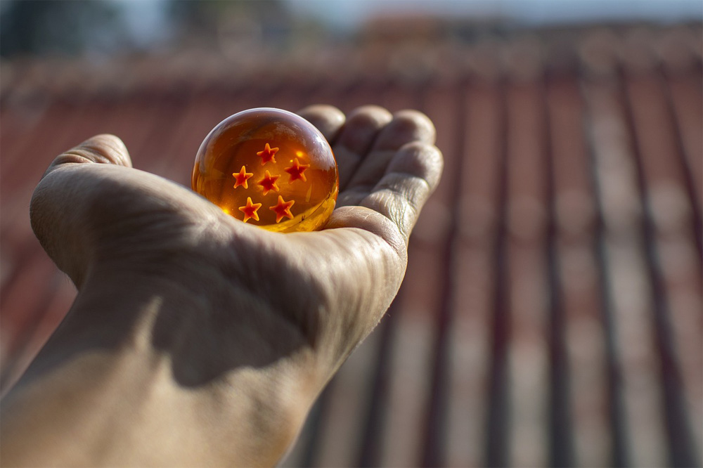 a picture of a toy Dragon Ball held in an outstretched hand