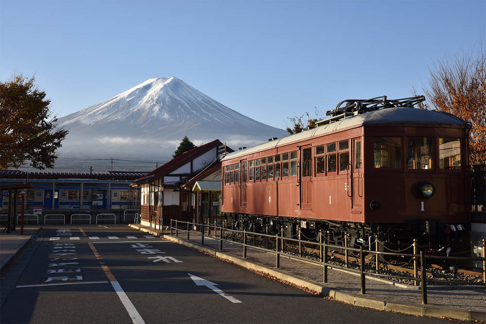 Mount Fuji with a Japanese railroad system in the foreground, complete with train and station of traditional design