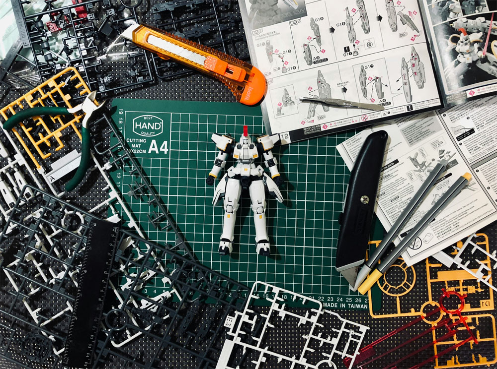 A gundam with building tools, a map, and instructions